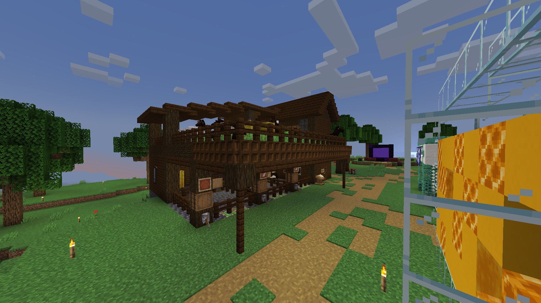 A two-level horse barn made of dark oak. The top layer is a pasture with hay bales and grass, while the bottom layer has stalls showcasing the horses currently for sale.